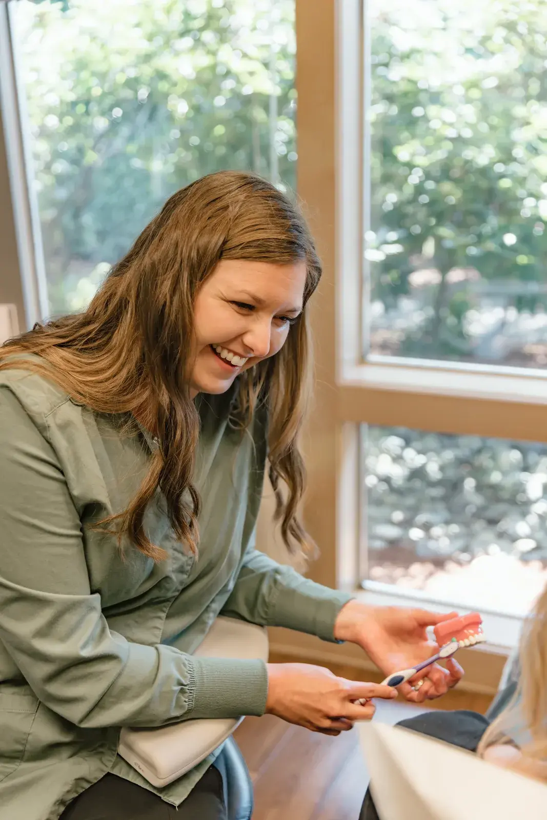 A hygienist showing a patient proper brushing technique